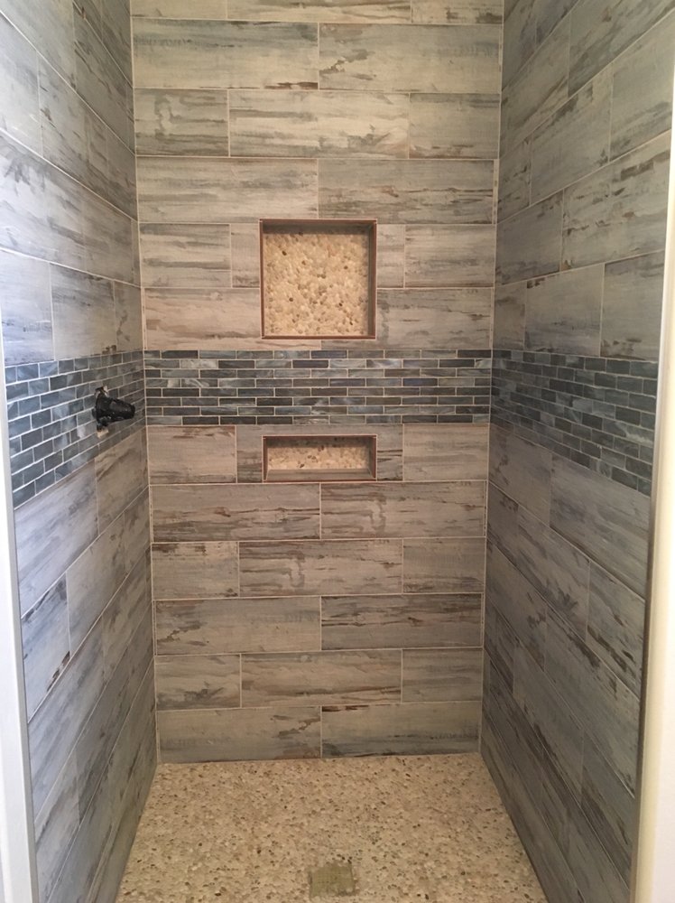 Glass tile mosaic shower with pebble floor and shampoo — Bathroom Remodeling by Urban Element, Inc. in the East Valley of Arizona